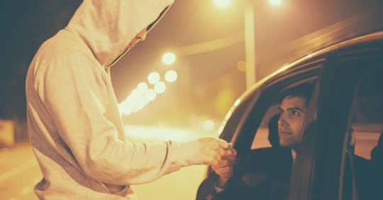 guy handing drugs secretly